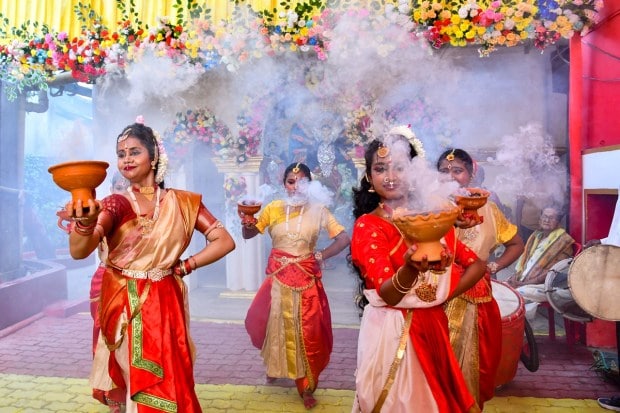 Devotees perform 'Aarti' (traditional Dhunuchi dance) on 'Maha Saptami' of the Durga puja festival at a puja pandal, in Tezpur, Assam. (PTI Photo)