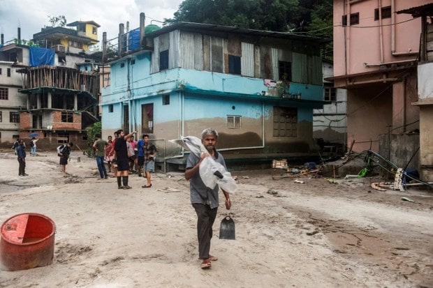 A man carrying shovels walks along an area affected by the flood near the bank of Teesta River at Singtam in Sikkim. (Reuters Photo)