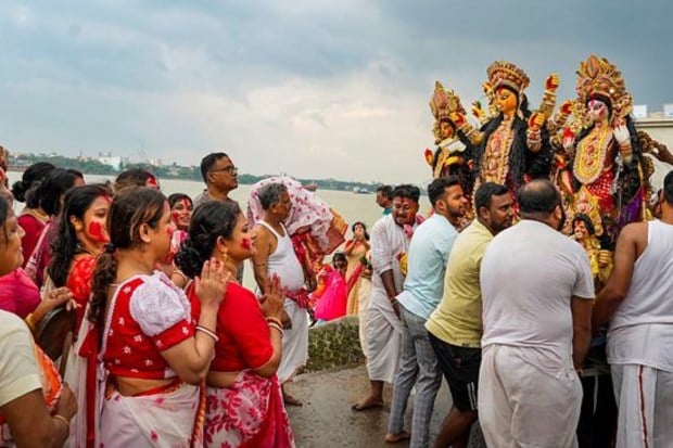 Devotees carry an idol of Goddess Durga for immersion in Ganga river on ‘Vijayadashami’ in Kolkata. (Image: PTI)