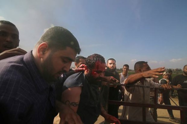 Palestinians transport a captured Israeli civilian, center, from Kfar Azza kibbutz into the Gaza Strip on October 7. (Image: AP)