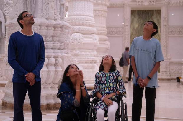 From left, Pritesh Patel, Avani Patel and their children, 11-year-old Prapti Patel and 15-year-old Nischay Patel, look up in awe at the ornate ceiling of the BAPS Swaminarayan Akshardham. (AP Photo)