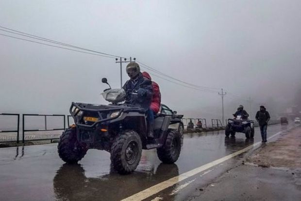 Tourists ride on all-terrain vehicles (ATV) at a resort after snowfall, in Gulmarg. (PTI Photo)