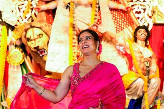 Actor Kajol poses for photos at a pandal of North Bombay Sarbojanin Durga Puja, in Mumbai. (PTI Photo)