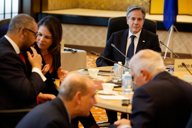 U.S. Secretary of State Antony Blinken, rear, looks on as British Foreign Secretary James Cleverly, left, and German Foreign Minister Annalena Baerbock, second left, interact during a session of the Group of 7 Foreign Ministers meetings in Tokyo.(AP Photo)