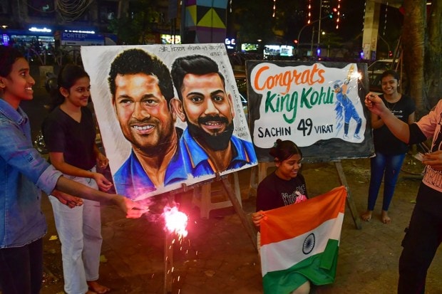 Fans celebrate after Virat Kohli equalled Sachin Tendulkar's record of 49 ODI centuries during the ICC Men's Cricket World Cup 2023 match against South Africa in Kolkata on Sunday. (PTI Photo)