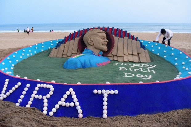 Sand artist Sudarsan Pattnaik creates a sand sculpture on the eve of Indian cricketer Virat Kohli' birthday in Puri. (PTI Photo)