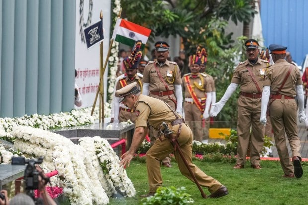 Personnel of the National Security Guard, Mumbai police and Indian Revenue Service officer Sameer Wankhede participated in a candle and flag march held at the Gateway of India, opposite the Taj Mahal Palace Hotel, one of the terror attack sites. (PTI Photo)