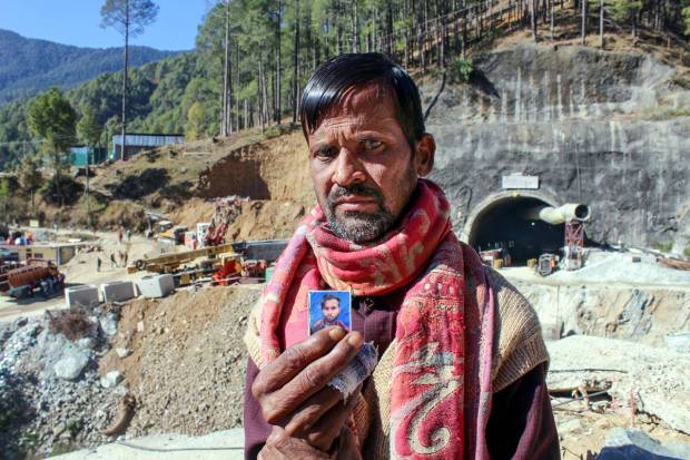 A relative shows a photo of a worker trapped inside the under-construction tunnel between Silkyara and Dandalgaon on the Brahmakhal-Yamunotri national highway, in Uttarkashi district. (PTI Photo)