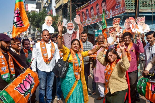 Varanasi: BJP workers and supporters celebrate the party's lead in Madhya Pradesh, Rajasthan and Chhattisgarh during counting of votes, in Varanasi. (PTI Photo)