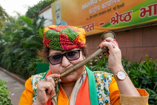 A BJP worker celebrates the party's lead in Madhya Pradesh, Rajasthan and Chhattisgarh during counting of votes for the Assembly elections, at the party headquarters, in New Delhi. (PTI Photo)