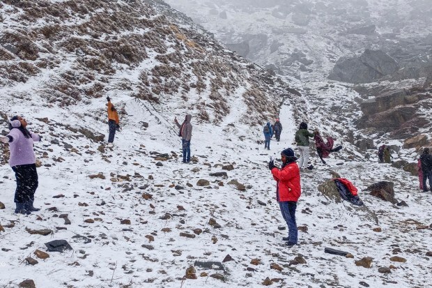 Lahaul & Spiti: Tourists click photographs at snow-covered Koksar after fresh snowfall, in Lahaul & Spiti district. (PTI Photo)