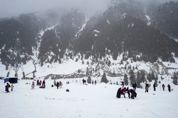 Tourists at snow-covered Sonamarg after fresh snowfall, in Ganderbal district. (PTI Photo)
