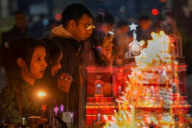 People visit the illuminated Sacred Heart Cathedral on Christmas eve in New Delhi. (PTI)