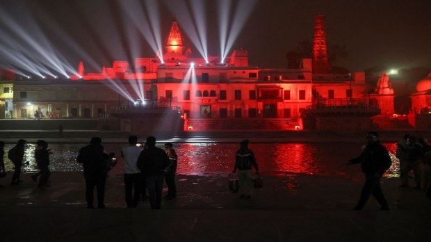 Devotees capture images on their mobile phones of the illuminated temples along the Sarayu riverbanks in Ayodhya, India, after evening prayers on December 29, 2023. (Image: Reuters)