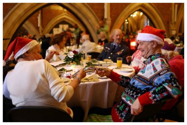 Guests joyfully pull a cracker during a heartwarming lunch at Jackson's Lane Arts Centre in north London, providing meals for isolated older and disabled community members since 1975 on Christmas Day. (Image: Reuters)