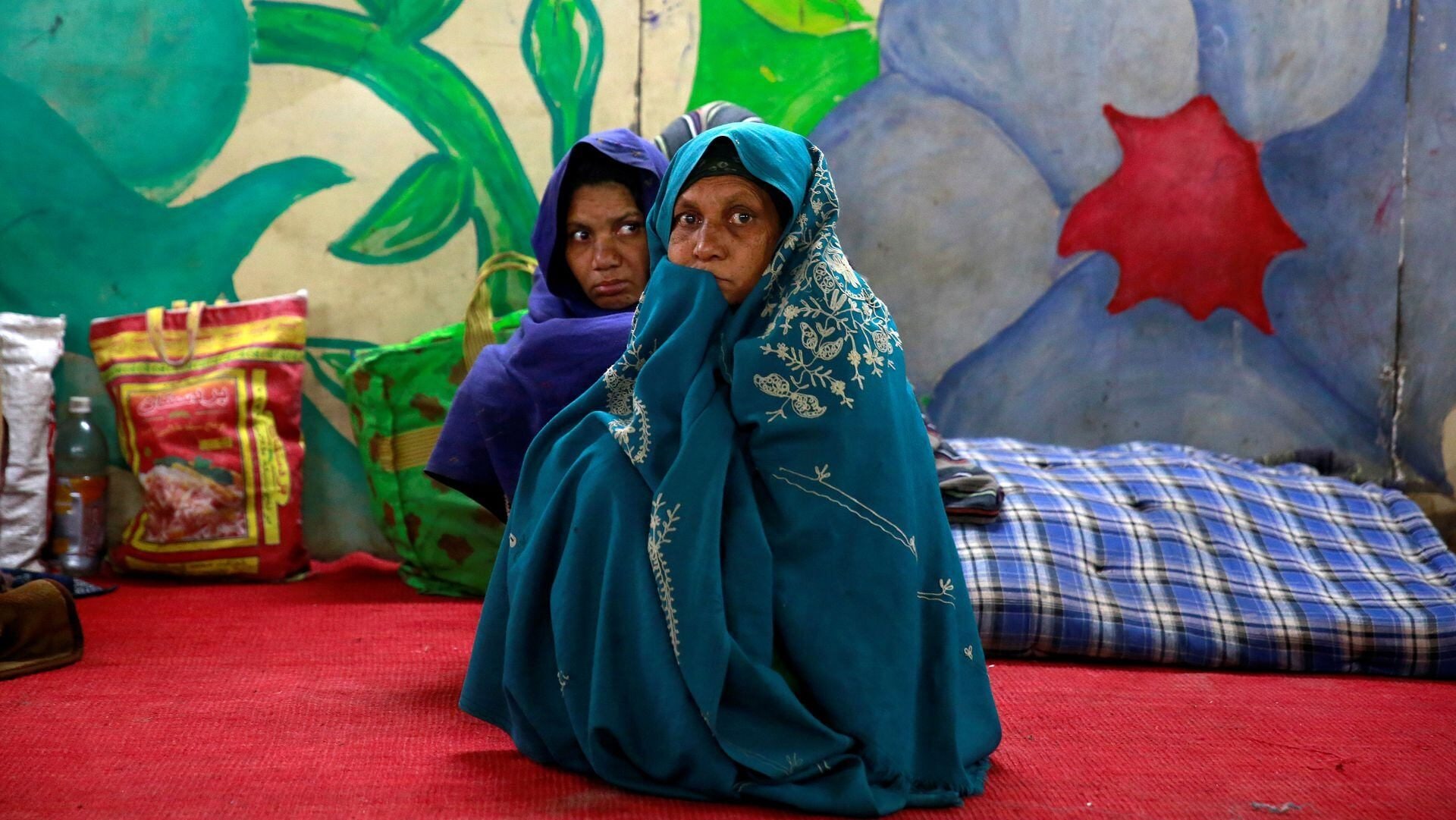 Women wrap themselves in blankets to escape the cold in Delhi (Image/Reuters)