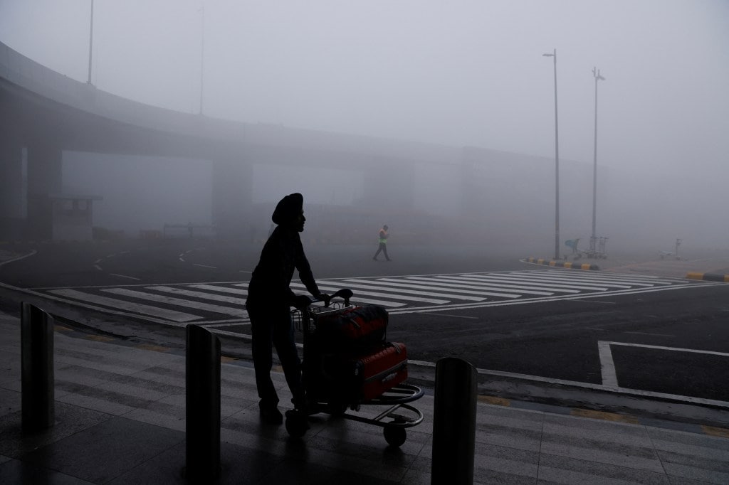 A man is seen with his luggage cart amidst heavy fog at the Indira Gandhi International Airport in New Delhi, India (Image/Reuters)