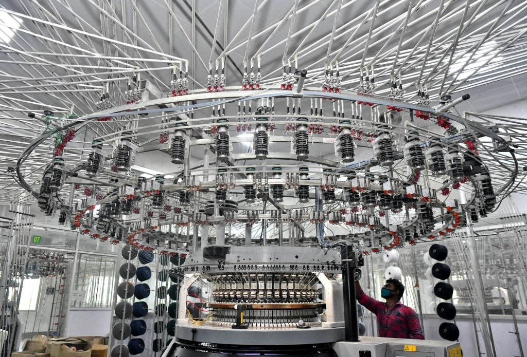 A worker operates a knitting machine at a textile factory of Texport Industries in Hindupur town in Andhra Pradesh (Image/Reuters)