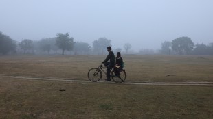 A man cycles with a schoolgirl on the pillion as they are on their way to school on a cold winter morning in New Delhi (Image/Reuters)