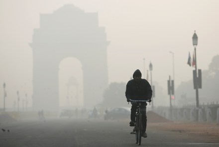 A man rides his bicycle in front of the India Gate (Image/Reuters)
