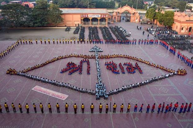 Students of Gurukul Vidhyalaya sit in the formation of a bow and arrow, ahead of the consecration ceremony of Ayodhya’s Ram Mandir, in Surat, Saturday, Jan. 20, 2024. (PTI Photo)
