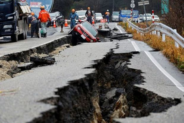 Workers repair a road next to a car stuck on a broken road, in the aftermath of an earthquake, near Anamizu, Japan, January 3, 2024. (Photo: Reuters)