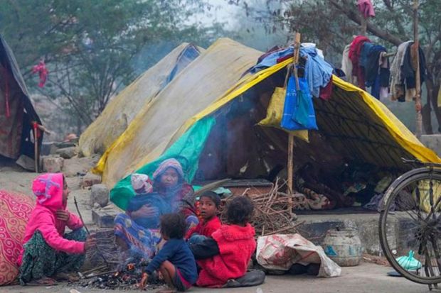 People sit around a bonfire during a cold and foggy winter morning, in New Delhi, Friday. (PTI Photo)