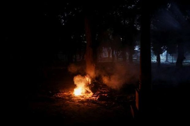 A man warms himself by a fire on the banks of the river Yamuna on a cold winter morning in New Delhi, India on January 5. (Reuters Photo)
