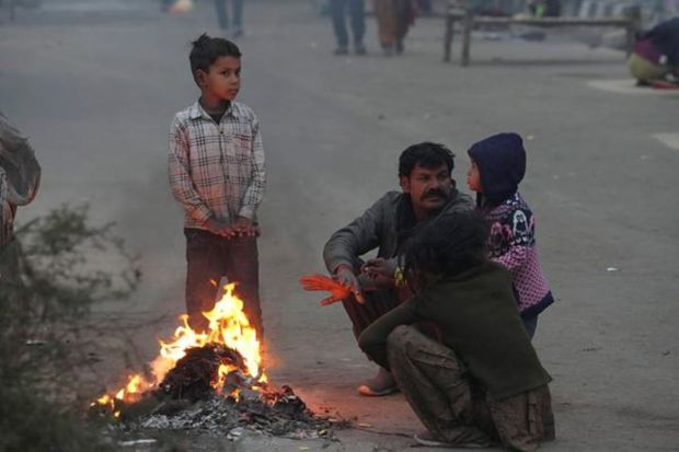 Men warm themselves by a fire on the banks of the river Yamuna on a cold winter morning in New Delhi, India on January 5. (Reuters Photo)