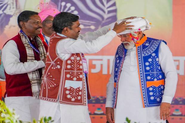 Prime Minister Narendra Modi being presented a headgear during the 'Janjatiya Sammelan' in Jhabua, Madhya Pradesh. (PTI Photo)