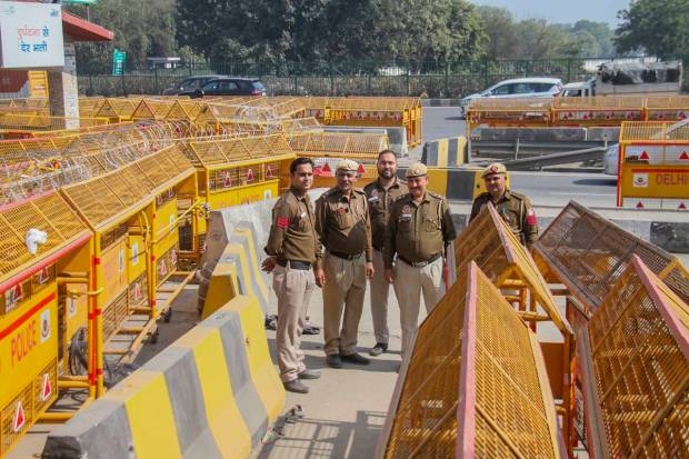 Police personnel stand guard at a barricaded road at Delhi-Gurugram border near Sirhaul toll plaza, during Samyukta Kisan Morcha's (SKM) Bharat Bandh, in Gurugram. (PTI Photo)