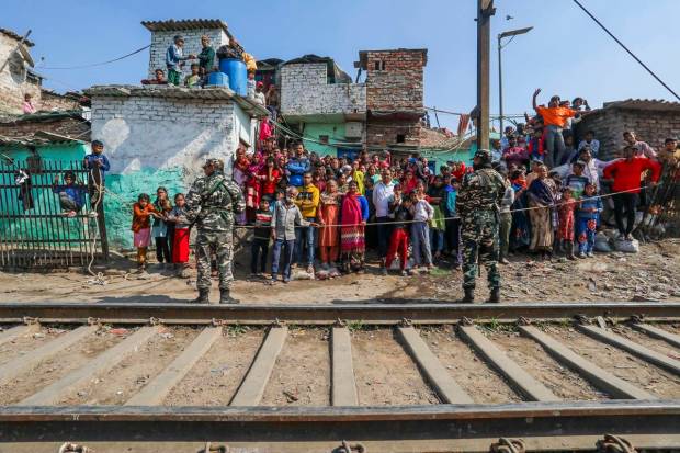 People gather after a goods train derailed near Zakhira in New Delhi. (PTI Photo)