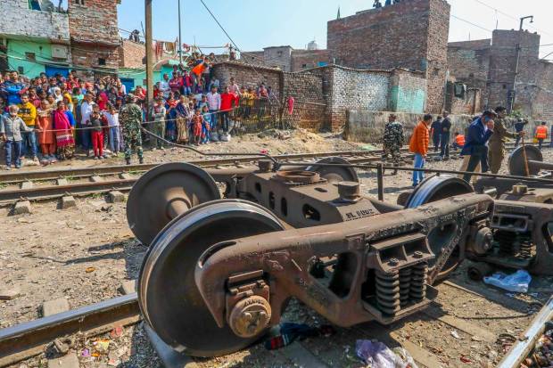 People gather to watch after a goods train derailed near Zakhira in New Delhi. (PTI Photo)
