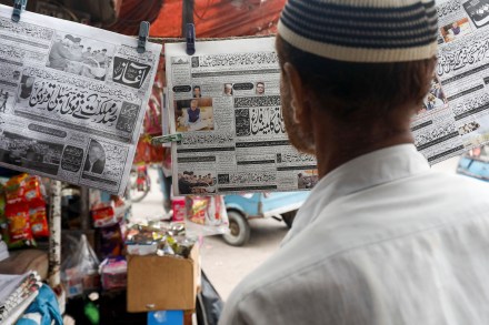 A man reads a newspaper at a stall in Karachi (Image/Reuters)