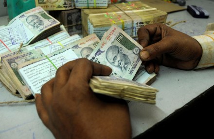 An employee counts currency notes at a cash counter inside a bank in Agartala, India (Image/Reuters)