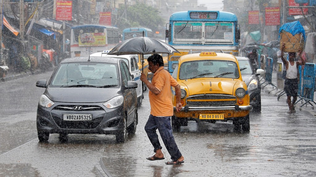 A man carrying an umbrella runs as he crosses a busy road during heavy rains in Kolkata (Image/Reuters) A man carrying an umbrella runs as he crosses a busy road during heavy rains in Kolkata (Image/Reuters)