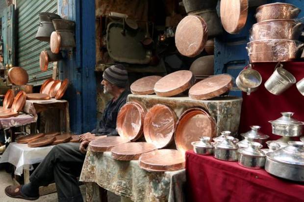 Tunisia coppersmith, Abdel Jalil Ayari, sits outside his shop in the old city of Tunis, ahead of the Muslim holy month of Ramadan, Tunisia. REUTERS