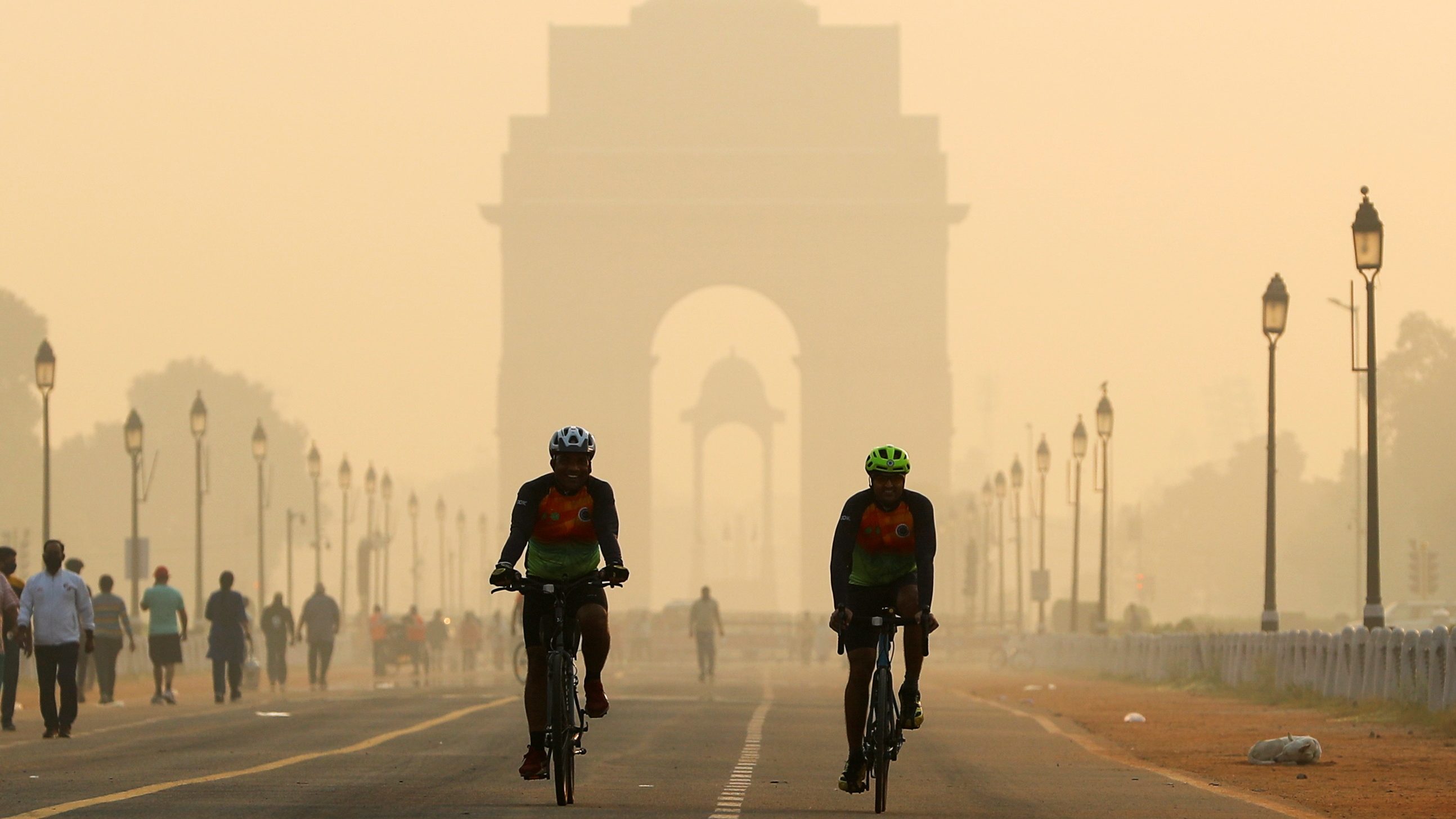 Men ride their bicycles in front of the India Gate in New Delhi (Image/Reuters)