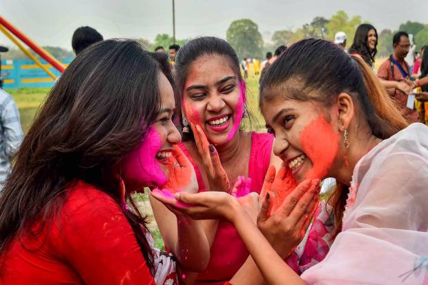 Young women play Holi with colours ahead of Basant Utsav festival, at Maidan area in Kolkata. (PTI Photo)