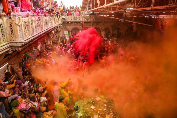 Devotees play with colours during Ladoo Holi celebrations at the Sriji temple in Barsana, near Mathura. (PTI Photo)
