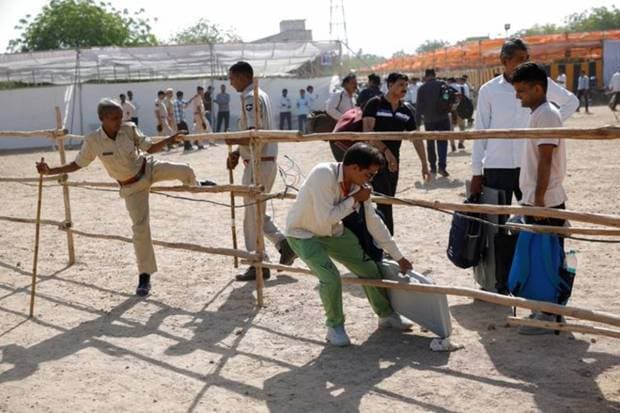 An election official makes his way as he carries an Electronic Voting Machines (EVM) at a distribution centre ahead of the second phase of the general elections, in Barmer in the desert state of Rajasthan. REUTERS