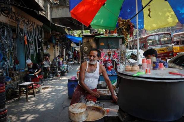 A tea vendor waits for customers at a market on a hot summer day in Kolkata. REUTERS