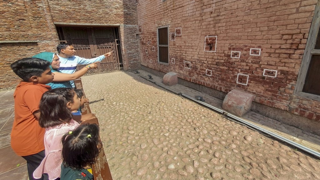Visitors look at a wall with bullet marks during their visit to the Jallianwala Bagh Martyrs' Memorial on the eve of the Jallianwala Bagh massacre anniversary, in Amritsar, Friday, April 12, 2024. (PTI Photo)