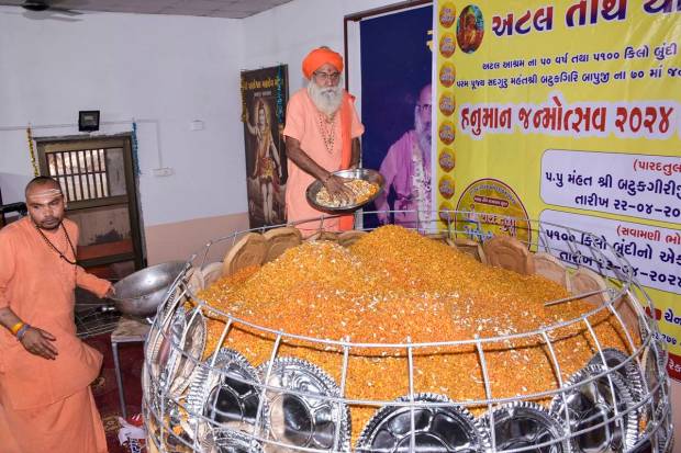 Devotees prepare a big 'ladoo' ahead of 'Hanuman Jayanti', at an ashram in Surat. (PTI Photo)