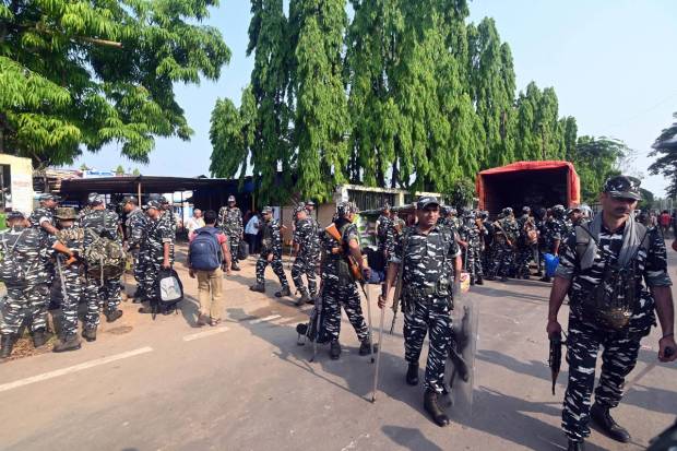 Security personnel wait to leave for various polling stations on the eve of the 2nd phase of Lok Sabha elections, at Dharmanagar in North Tripura. (PTI Photo)