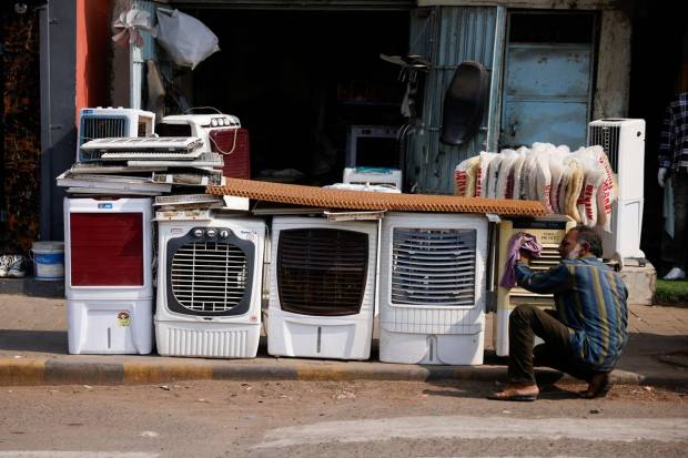A man cleans dust from air coolers kept on display for sale on the road on a hot summer day in Ahmedabad. REUTERS