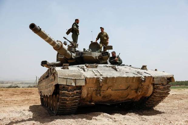 Israeli soldiers operate atop a tank near the Israel-Gaza border, amid the ongoing conflict between Israel and the Palestinian Islamist group Hamas, as seen from Israel. REUTERS
