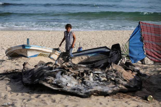 A Palestinian girl inspects boats damaged in Israeli fire, amid the ongoing conflict between Israel and Palestinian Islamist group Hamas, in Rafah in the southern Gaza Strip. REUTERS