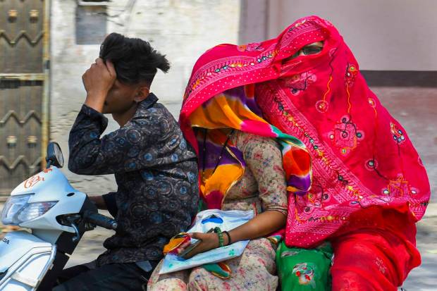Commuters cover themselves for protection against the scorching sun on a hot summer day, in Beawar. (PTI Photo)