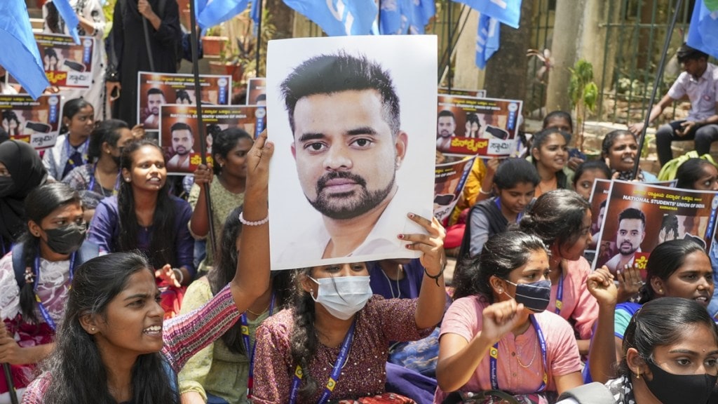 NSUI members hold a poster of JD(S) MP Prajwal Revanna during a protest against his involvement in the alleged sexual abuse case, in Bengaluru, Tuesday, April 30, 2024. (PTI Photo) NSUI members hold a poster of JD(S) MP Prajwal Revanna during a protest against his involvement in the alleged sexual abuse case, in Bengaluru, Tuesday, April 30, 2024. (PTI Photo)